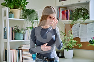 Young teenage girl touching her eyes with her fingers