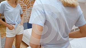 Young teenage girl trying clothes and looking at mirror smilng happy.