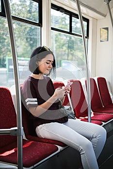 Young teenage girl using her cell phone in public transportation.