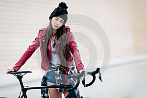 Young teenage girl waits on her bike with challenging look. School absenteeism concept