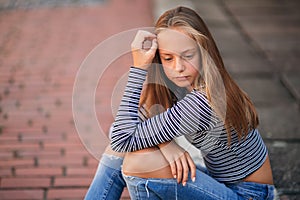 Young teenage poses for photo. blonde girl in jeans and blouse