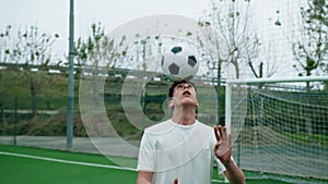 Young teenage soccer player makes dribbles with his head