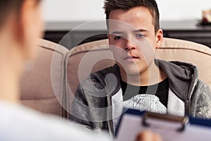 Young teenager boy at counseling - talking to the therapy professional, close up