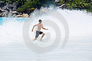 Young teenager boy enjoys summer holiday in sea. The kid runs away from huge wave.