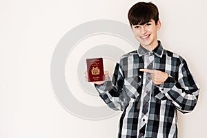 Young teenager boy holding Bolivia passport looking positive and happy standing and smiling with a confident smile against white