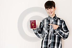 Young teenager boy holding Peru passport looking positive and happy standing and smiling with a confident smile against white