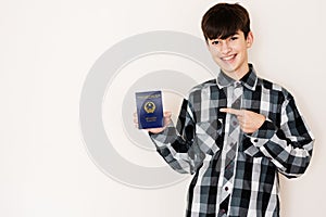 Young teenager boy holding Vietnam passport looking positive and happy standing and smiling with a confident smile against white