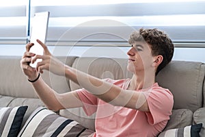 young teenager boy making a video call with the tablet