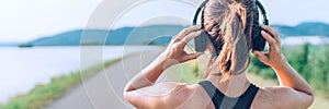 Young teenager girl adjusting  wireless headphones before starting jogging and listening to music. Web page header cropping