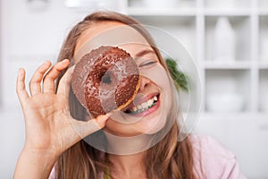 Young teenager girl having fun with a donut
