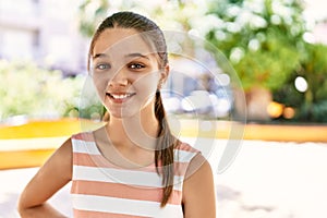 Young teenager girl outdoors on a sunny day looking positive and happy standing and smiling with a confident smile showing teeth