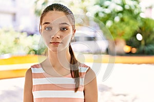 Young teenager girl outdoors on a sunny day thinking attitude and sober expression looking self confident