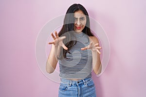 Young teenager girl wearing casual striped t shirt afraid and terrified with fear expression stop gesture with hands, shouting in