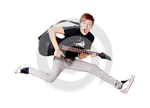 Young teenager jumping with guitar