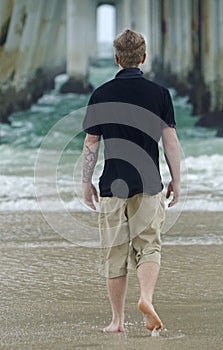 Young teenager man alone stunning beach confused with life