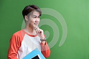 Young teenager man holding tablet computer and notebook and thin