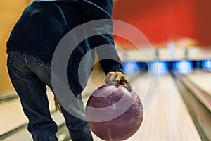 Young teenager playing bowl grabbing pink ball