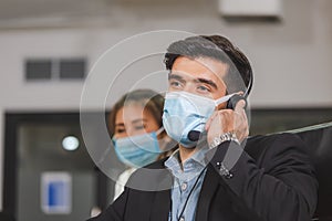 Young telephone operator with headset wear protection face mask against coronavirus, Customer service executive team working at