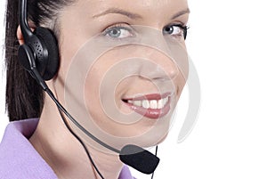 Young adult female telephonist with telephone headset, smiling, eyes looking at camera, close up
