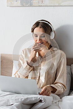 Young teleworker in headphones using blurred photo