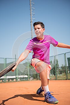 Young tennis player playing backhand and glide on a sunny day. photo