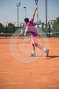 Young tennis player playing backhand with high impact