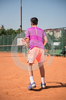 Young tennis player prepares for receiving the servis. High concentration.