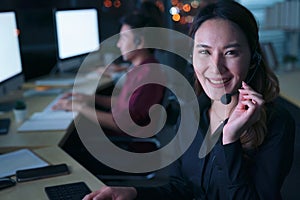 Young Thai Asian customer services care operators working night shift in call center for helping assistance client in workplace at