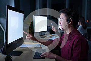 Young Thai Asian customer services care operators working night shift in call center for helping assistance client in workplace at