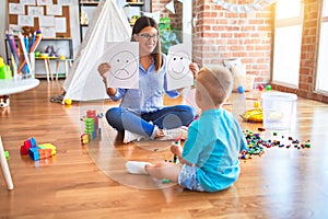 Young therapist woman speaking with child, counselor and behaviour correction at the office showing happy and sad face