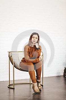 young thin girl in a knitted suit on a light background. Tenderness, femininity.