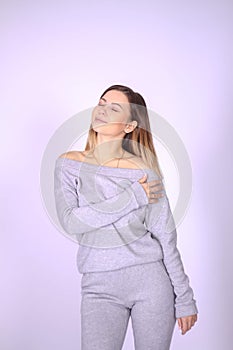 young thin girl in a knitted suit on a light background. Tenderness, femininity.