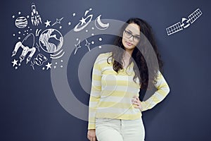 Young thinkful woman on blue gray background with universum icons.