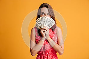 Young thinking pretty woman in red dress hiding behind bunch of