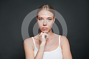 Young thinking woman on gray background