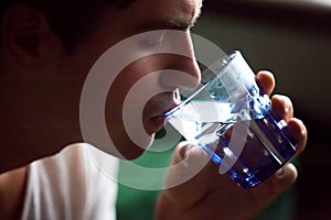 Young thirsty dehydrated man drinking water quenching thirst, cl