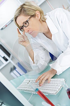 Young thoughtful female chemist working in lab