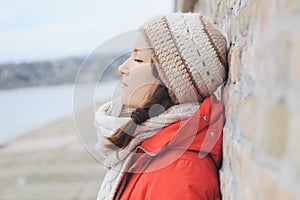 Young thoughtful lonely woman in winter clothes