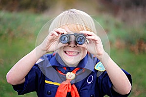 Young Tiger Cub Scout Smiling at Camera Through Binoculars photo