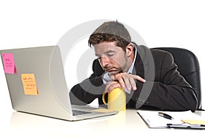 Young tired and wasted businessman working in stress at office laptop computer looking exhausted photo