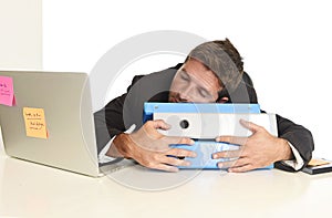 Young tired and wasted businessman working in stress at office laptop computer sleeping exhausted