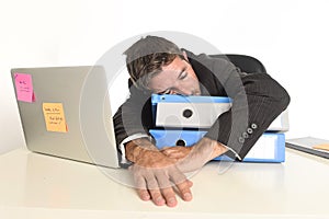 Young tired and wasted businessman working in stress at office laptop computer sleeping exhausted photo