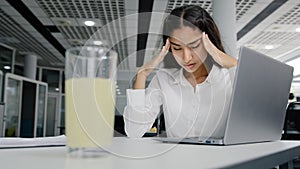 Young tired woman manager sits in office feels headache suffers from pain overwork unhealthy girl office worker feeling