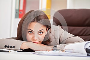 Young tired woman at office desk sleeping with eyes closed, sleep deprivation and stressful life concept