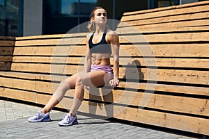 Young tired woman resting after workout session on a day.