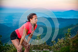 Young tired woman during trail running in mountains