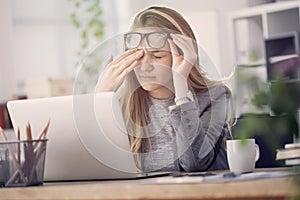 Young tired working woman at work photo