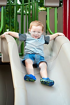 Young toddler boy child playing on slide