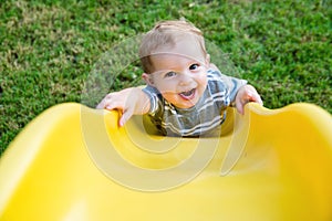 Young toddler boy child playing on slide