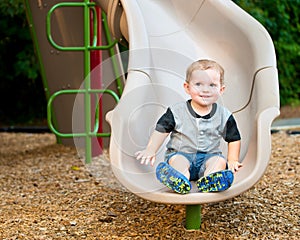 Young toddler boy child playing on slide